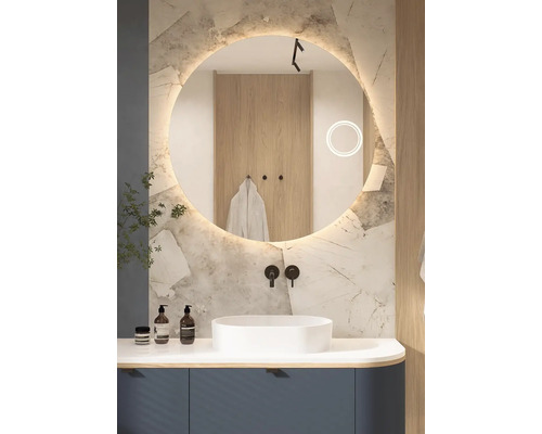 Modernt badrum med rund spegel, tvättställsskål och armaturer