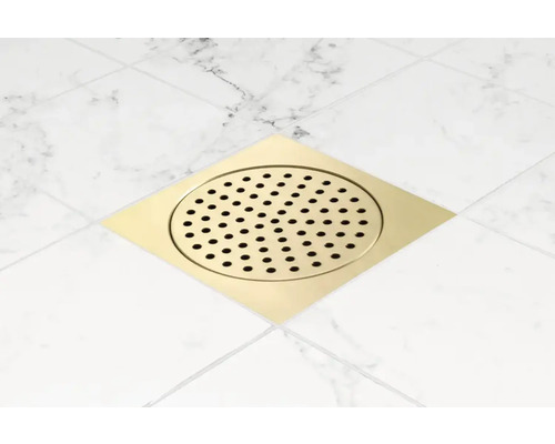 Fyrkantigt golvbrunn i metall med runt perforerat lock på plattor