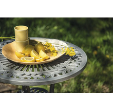 Scen med citroner, dricksglas och blommor på ett trädgårdsbord
