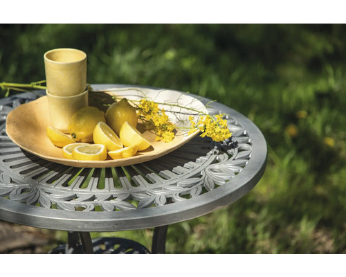 Scen med citroner, dricksglas och blommor på ett trädgårdsbord