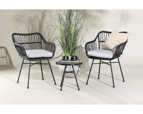 Två rottingfåtöljer med dynor och ett sidobord med dekoration för trädgården.