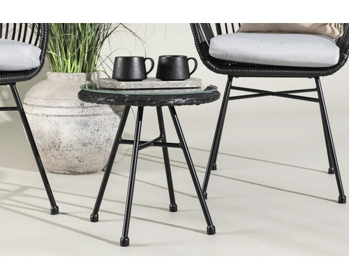 Trädgårdsscen med svart sidobord, två muggar och rottingstolar