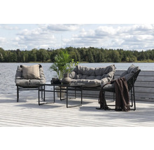 Trädgårdsmöbelset med soffa, stolar och bord på en träterrass vid sjön