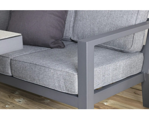 Närbild av en grå trädgårdssoffa med kuddar och aluminiumram.