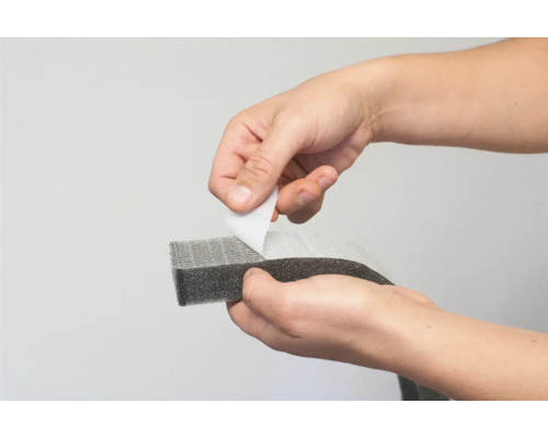 Händer drar bort skyddsfilmen från en tätningslist