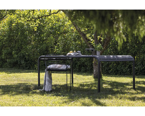 Trädgårdsscen med bord, stol och dekoration under ett träd