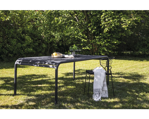 Trädgårdsscen med matbord, stol och dekoration på en gräsmatta utomhus