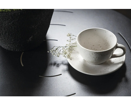 Teekopp med fat och dekoration på ett bord