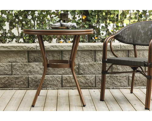 Trädgårdsbord med glasskiva och matchande stol på en terrass