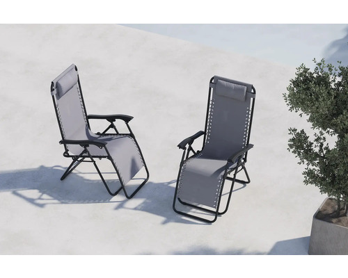 Två relaxstolar i metall med tygklädsel och nackkudde står på en terrass.