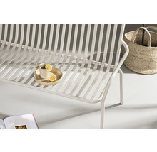Detaljbild av en vit trädgårdssoffa med citron och korg