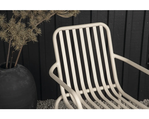 Detaljvy av en trädgårdsfåtölj i metall med armstöd och ribbmönster