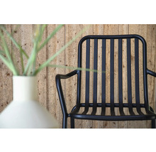 Svart metallfåtölj bredvid en vas