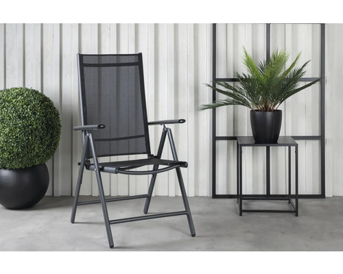 Trädgårdsscen med en hopfällbar stol, ett sidobord och två växter