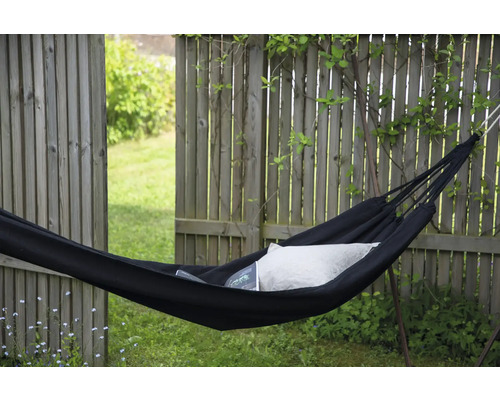 Svart hängmatta med kudde i trädgården