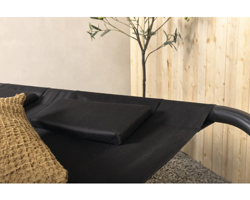 Detaljvy av en svart hängmatta med kuddar och dekoration
