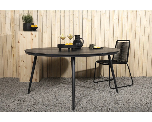 Runt trädgårdsbord i metall med en stol på en terrass