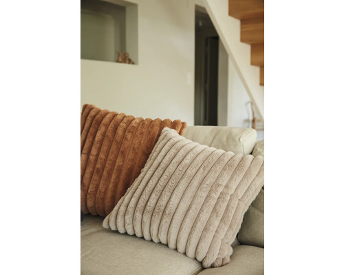 Dekorativa kuddar med ribbad struktur på en soffa