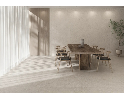 Ljust matrum med träbord, stolar, gardiner och krukväxt.