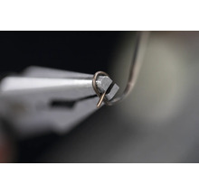 En tång böjer en tråd.