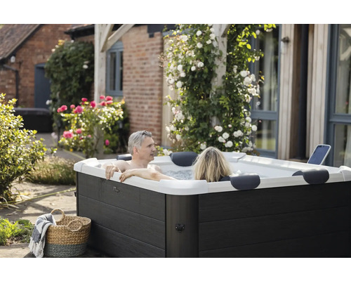 Par kopplar av i en bubbelpool i trädgården