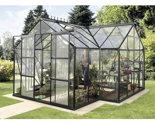 Växthus med växter och en person i trädgården.