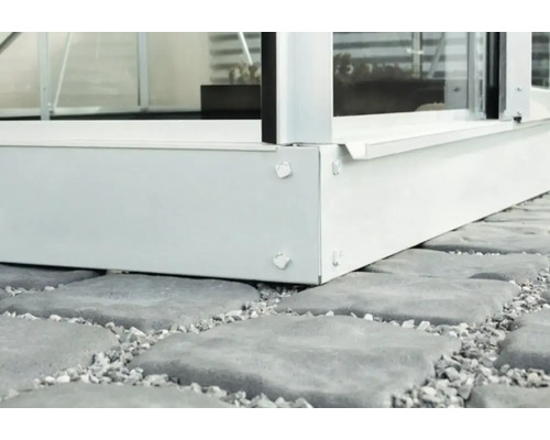 Detaljvy av en metallväxthusgrund på en stenbeläggning