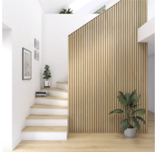 Ljust rum med trappa, träpanelvägg och krukväxter.