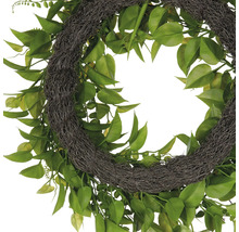 Dekorativ krans med gröna blad och en bas av naturmaterial