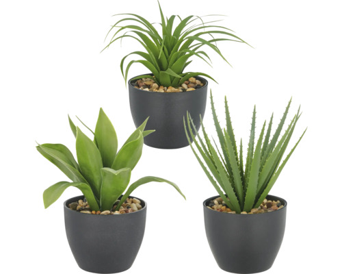 Tre konstgjorda krukväxter med olika bladformer i svarta krukor