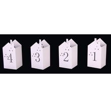 Fyra numrerade presentpåsar i form av ett hus med stjärnmönster.