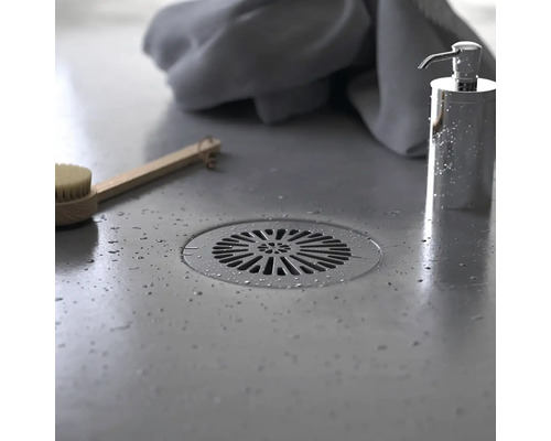 Överblicksbild av en handfatsyta med avlopp, tvålpump, borste och handduk