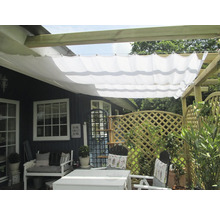 Terrass med solsegel, trädgårdsmöbler och trästaket