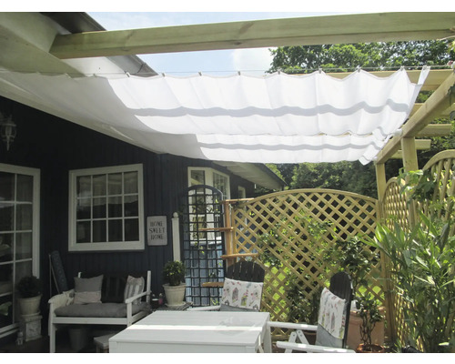 Terrass med solsegel, trädgårdsmöbler och trästaket