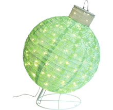 Dekorativ, upplyst julkula med snöflingamönster på ett stativ