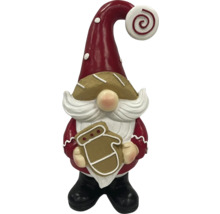 Dekorativ julnisse med pepparkaka i handen som juldekoration