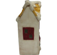 Dekorativt hus i keramik med snö på taket och skorsten.