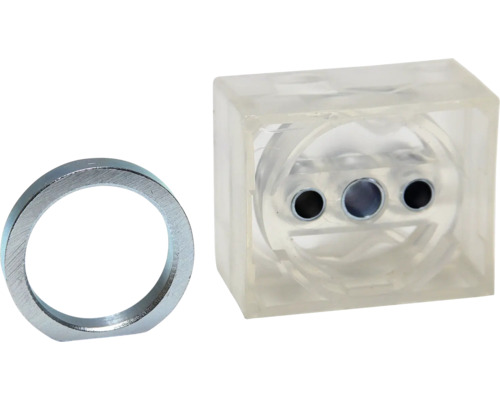 Metallring och genomskinlig kub med hål