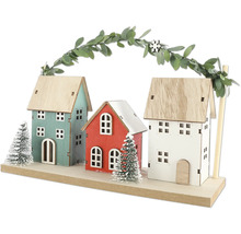 Dekorativ trähusscen med tre hus och girlang