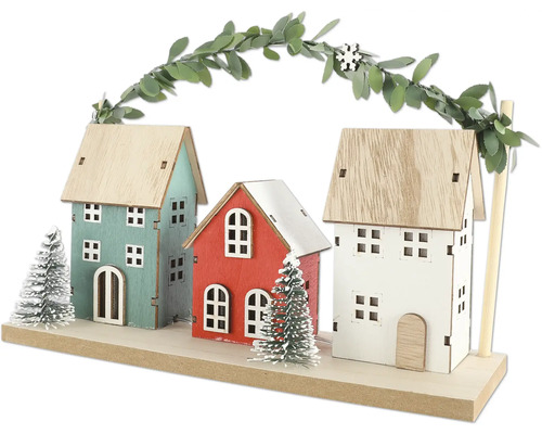 Dekorativ trähusscen med tre hus och girlang