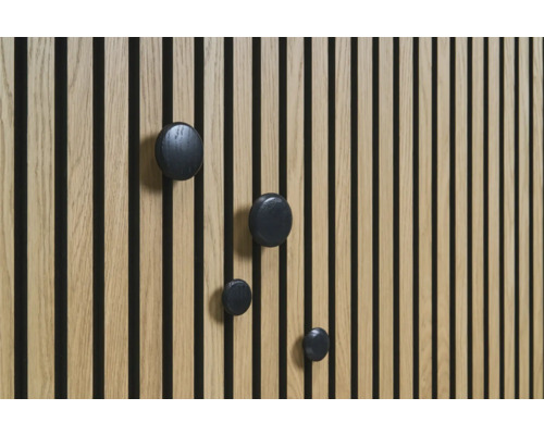 Träpanel med svarta, runda krokar