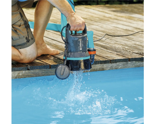 Man som använder en Gardena dränkbar pump för klart vatten vid poolen.