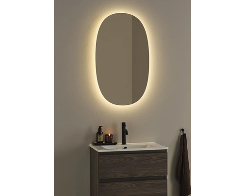 Badrum med belyst spegel, tvättställ och armatur