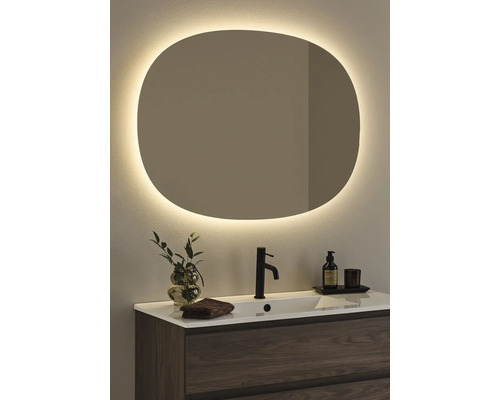 Badrum med handfat, kran och belyst spegel