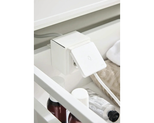 Uttagselement i badrumsskåp med öppet lock