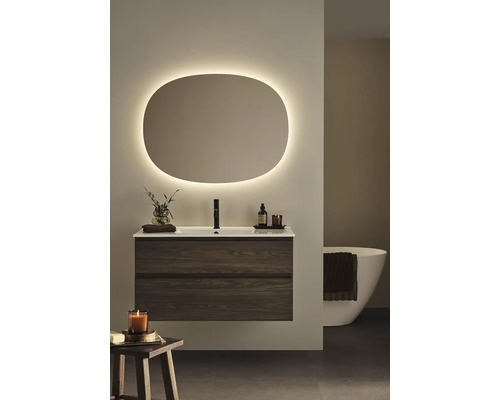 Modernt badrum med tvättställsskåp, spegel med belysning och badkar