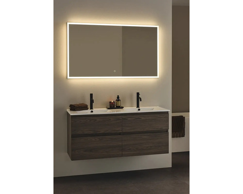 Badrum med belyst spegel, tvättställsskåp och två handfat