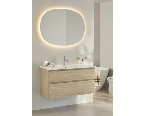 Badrum med tvättställsskåp, handfat och belyst spegel