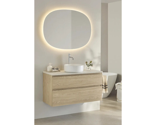 Badrum med tvättställsskåp, tvättställsskål och belyst spegel