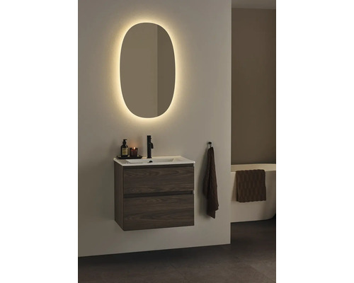 Badrum med tvättställsskåp, handfat, armatur och belyst spegel